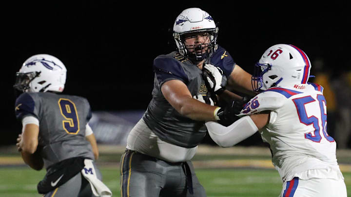 Copley quarterback Gabe Mansel looks to throw as offensive lineman Lucas Tielsch blocks Revere defensive lineman Joe Sunkin during the first half of their game at Copley High School on Friday Oct. 18, 2024.