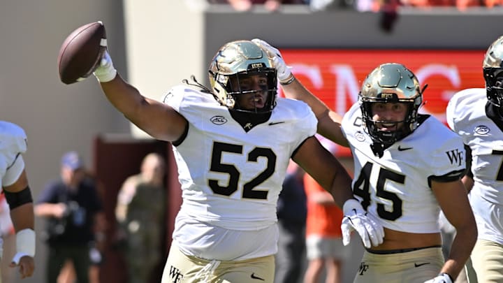 Oct 4, 2025; Blacksburg, Virginia, USA;  Wake Forest Demon Deacons defensive lineman Dallas Afalava (52) and defensive back Nick Andersen (45) celebrate a fumble recovery during the first quarter against the Virginia Tech Hokies at Lane Stadium. Mandatory Credit: Brian Bishop-Imagn Images