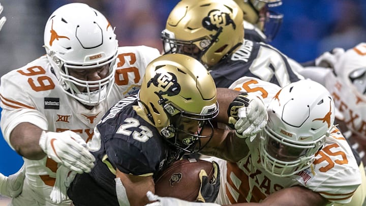Texas Longhorns defensive lineman Keondre Coburn (99) and Texas Longhorns defensive lineman Alfred Collins (95) gang tackle Colorado Buffaloes running back Jarek Broussard during an NCAA college football game at the Valero Alamo Bowl at the Alamodome on Tuesday, Dec. 29, 2020, in San Antonio.