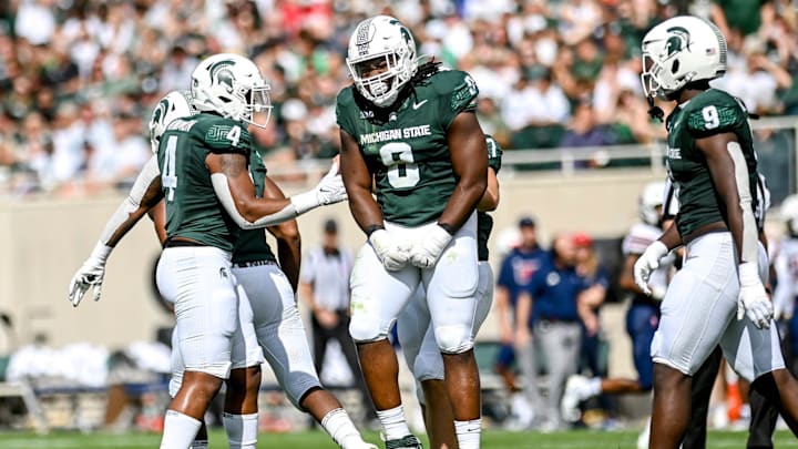 Michigan State's Simeon Barrow Jr., center, celebrates his sack against Richmond during the first