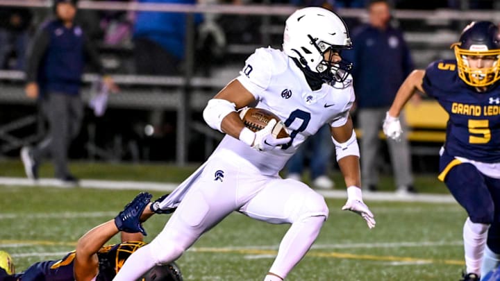 East Lansing's Jace Clarizio runs for a gain against Grand Ledge during the first quarter on Friday,