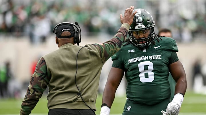 Michigan State's interim head coach Harlon Barnett, left, pats Simeon Barrow Jr. on the helmet during the first quarter in the game against Nebraska on Saturday, Nov. 4, 2023, at Spartan Stadium in East Lansing.