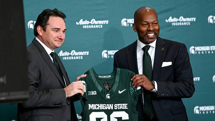 Michigan State football coach Jonathan Smith, left, and athletic director Alan Haller pose with a jersey during an introductory press conference for the new coach on Tuesday, Nov. 28, 2023, at the Breslin Center in East Lansing.