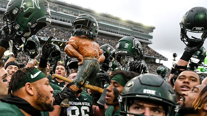 Michigan State celebrates with the Paul Bunyan Trophy after beating Michigan on Saturday, Oct. 30, 2021, at Spartan Stadium in East Lansing.