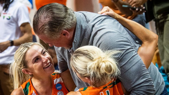 Miami (FL)'s Hanna Cavinder (15) and Haley Cavinder (14) hug their father after the second half of the NCAA Tournament Second Round game between Indiana and Miami (FL) at Simon Skjodt Assembly Hall on Monday, March 20, 2023.