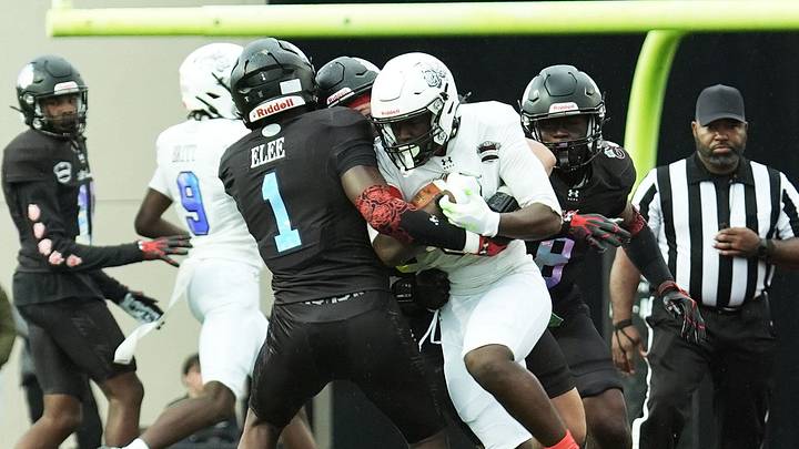 Team Pearls' Javari Barnett (5) runs with the ball as Team Roses' Zion Elee tries to tackle him during the Under Armour All-America Game. Team Pearls' Javari Barnett (5) runs with the ball as Team Roses' Zion Elee tries to tackle him during the Under Armour All-America Game.