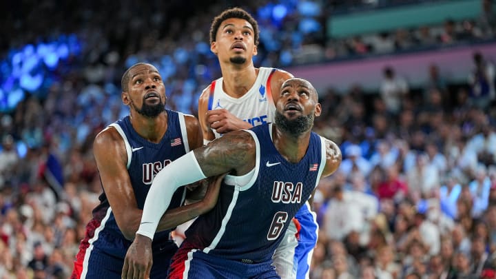 Kevin Durant and LeBron James (Team USA) box out Victor Wembanyama (France) in Saturday's gold medal game in Paris.