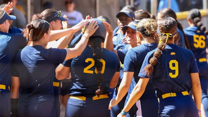 Tianna Bell (20) celebrates a home run with her teammates and coaching staff as she crosses home plate. Tianna Bell (20) celebrates a home run with her teammates and coaching staff as she crosses home plate.