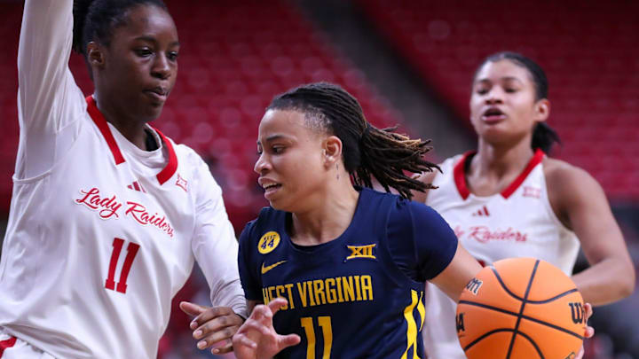 West Virginia's JJ Quinerly is met by Texas Tech's Sarengbe Sanogo on a drive to the basket during a Big 12 Conference women's basketball game, Wednesday, Jan. 8, 2025, in United Supermarkets Arena.