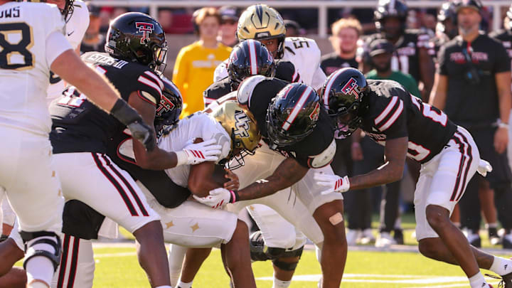 A swarm of Texas Tech defenders wrap up a UCF ball carrier during a Big 12 Conference football game, Saturday, Nov. 15, 2025, at Jones AT&T Stadium.