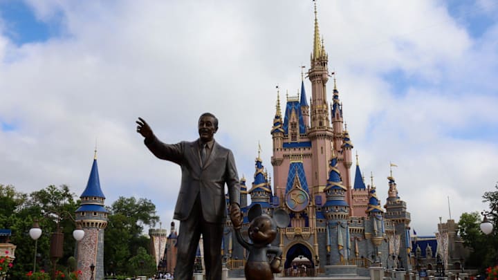 Celebrating the park's 50th Anniversary, visitors to Disney's Magic Kingdom pass a statue of Walt