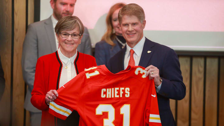 Kansas Gov. Laura Kelly and Kansas City Chiefs CEO Clark Hunt hold up a Chiefs jersey.