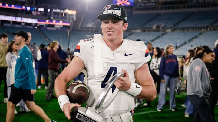 Dec 27, 2025; Jacksonville, FL, USA; Virginia Cavaliers quarterback Chandler Morris (4) celebrates with the MVP trophy after defeating the Missouri Tigers at EverBank Stadium. Mandatory Credit: Travis Register-Imagn Images
