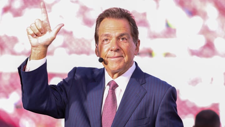 ESPN personality Nick Saban does the Guns Up gesture