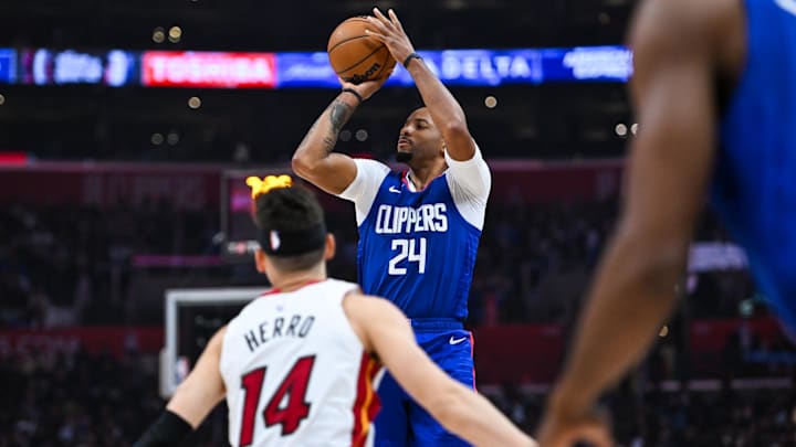 Jan 1, 2024; Los Angeles, California, USA; Los Angeles Clippers guard Norman Powell (24) shoots against Miami Heat guard Tyler Herro (14) during the second quarter at Crypto.com Arena. Mandatory Credit: Jonathan Hui-Imagn Images