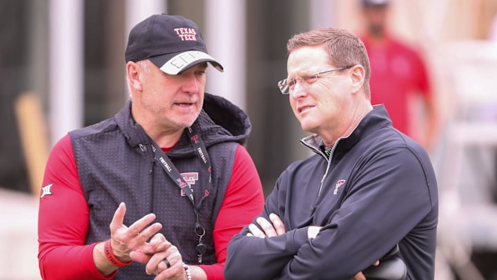 Texas Tech director of athletics Kirby Hocutt (right) speaks with Joey McGuire