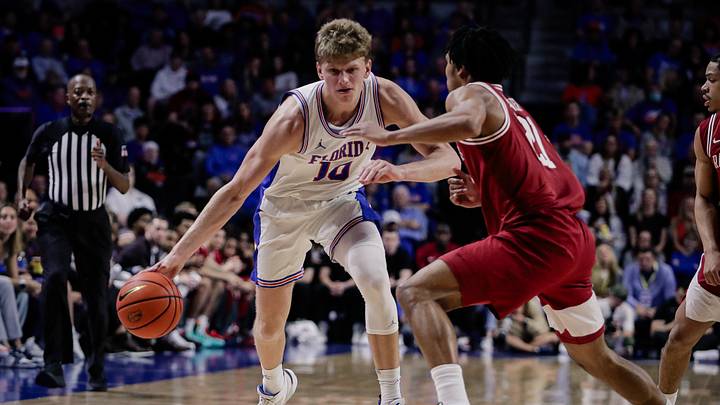 Feb 28, 2026; Gainesville, Florida, USA; Florida Gators forward Thomas Haugh (10) drives with the ball against Arkansas Razorbacks guard D.J. Wagner (21) during the second half at Exactech Arena at the Stephen C. O'Connell Center. Mandatory Credit: Travis Register-Imagn Images