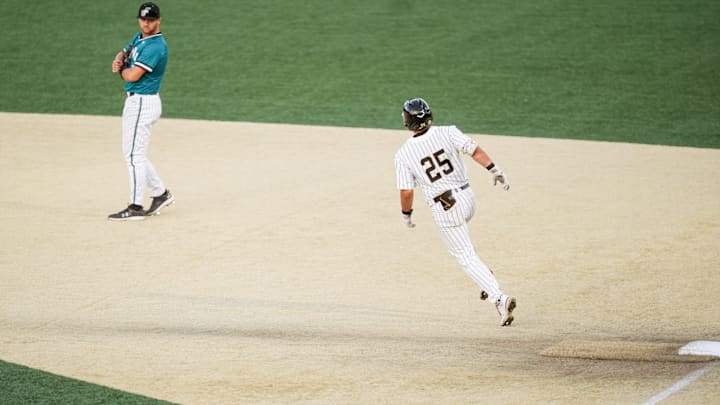 Wake Forest outfielder Boston Torres circles the bases as the Coastal Carolina first baseman looks on during the game on April 14. 