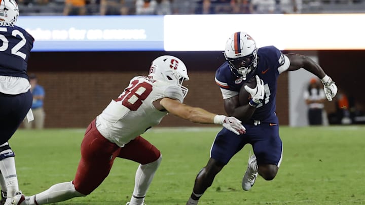 Sep 20, 2025; Charlottesville, Virginia, USA; Virginia Cavaliers running back Harrison Waylee (21) carries the ball as Stanford Cardinal linebacker Zach Johnson (38) attempts a tackle during the fourth quarter at Scott Stadium. Mandatory Credit: Geoff Burke-Imagn Images Sep 20, 2025; Charlottesville, Virginia, USA; Virginia Cavaliers running back Harrison Waylee (21) carries the ball as Stanford Cardinal linebacker Zach Johnson (38) attempts a tackle during the fourth quarter at Scott Stadium. Mandatory Credit: Geoff Burke-Imagn Images
