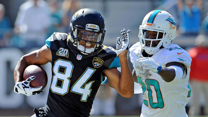 Oct 26, 2014; Jacksonville, FL, USA; Jacksonville Jaguars wide receiver Cecil Shorts III (84) runs the ball past Miami Dolphins safety Reshad Jones (20) during the first half of the game at EverBank Field. Mandatory Credit: Melina Vastola-Imagn Images