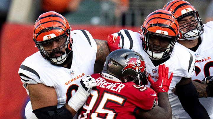 Cincinnati Bengals guard Cody Ford (61), left and Cincinnati Bengals center Trey Hill (63), right, block Tampa Bay Buccaneers defensive tackle C.J. Brewer (95) in the first quarter of the NFL preseason game at Paycor Stadium in Cincinnati on Saturday, August 10, 2024.