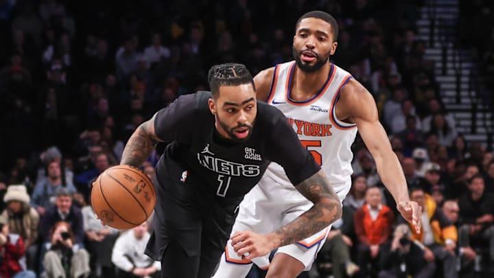 Jan 21, 2025; Brooklyn, New York, USA;  Brooklyn Nets guard D'Angelo Russell (1) drives past New York Knicks forward Mikal Bridges (25) in the fourth quarter at Barclays Center. Mandatory Credit: Wendell Cruz-Imagn Images