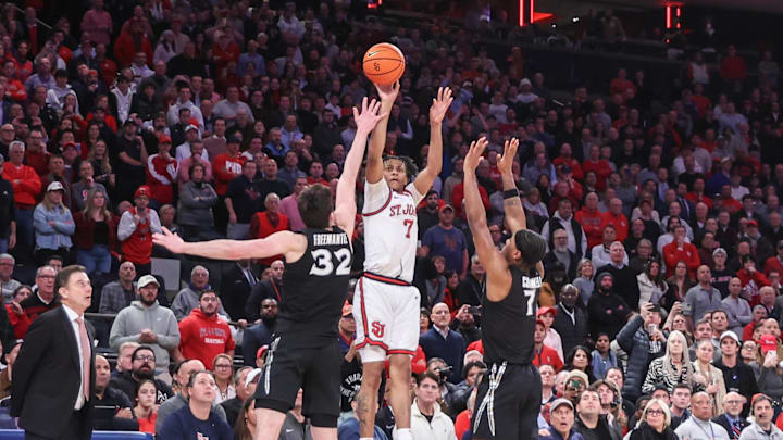 Jan 22, 2025; New York, New York, USA;  St. John's basketball guard Simeon Wilcher (7) takes a three point shot  past Xavier Musketeers forward Zach Freemantle (32) and  guard Ryan Conwell (7) in the second half at Madison Square Garden. 