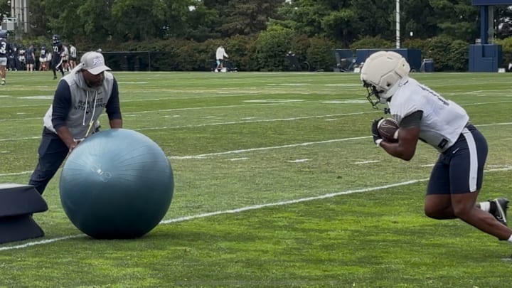 Penn State running back Nicholas Singleton goes through a drill with running backs coach Stan Drayton.