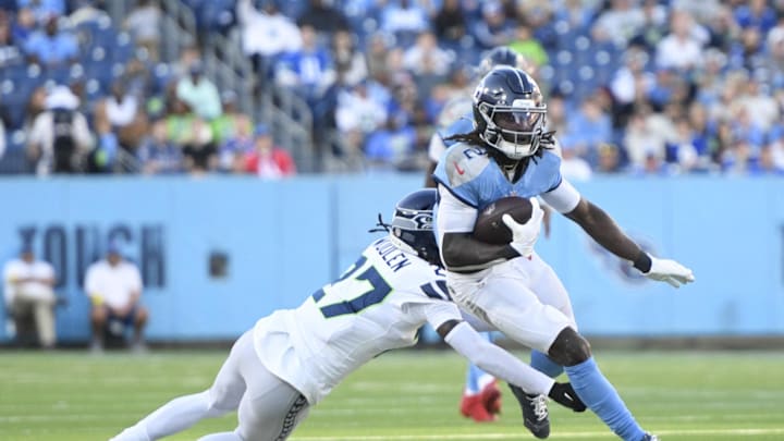 Nov 23, 2025; Nashville, Tennessee, USA; Tennessee Titans running back Tyjae Spears (2) runs against Seattle Seahawks cornerback Riq Woolen (27) during the second half at Nissan Stadium. Mandatory Credit: Steve Roberts-Imagn Images