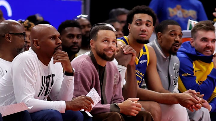 Golden State Warriors guard Stephen Curry, center Trayce Jackson-Davis and guard De'Anthony Melton on the bench during against the Houston Rockets at Toyota Center. 