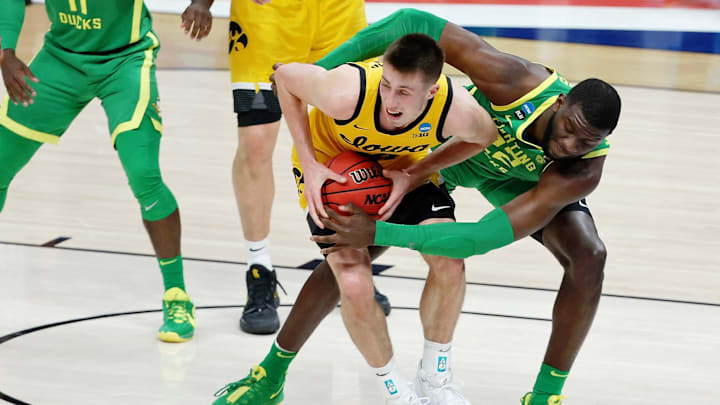 Franck Kepnang wraps up Iowa guard Joe Wieskamp for Oregon in the 2021 NCAA Tournament in Indianapolis.