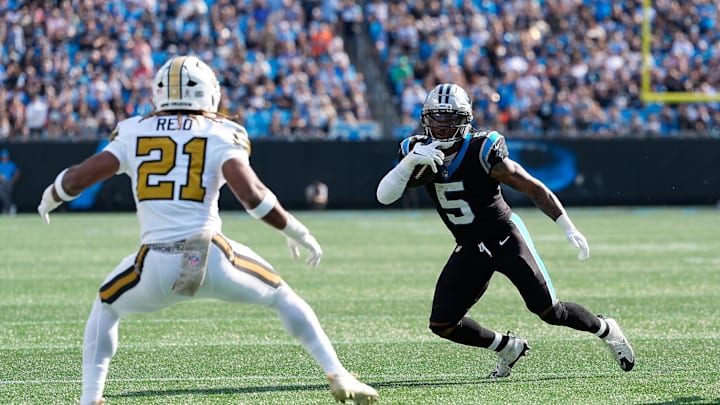 Nov 9, 2025; Charlotte, North Carolina, USA; Carolina Panthers running back Rico Dowdle (5) rushes as New Orleans Saints safety Justin Reid (21) defends during the first quarter at Bank of America Stadium. Mandatory Credit: Jim Dedmon-Imagn Images