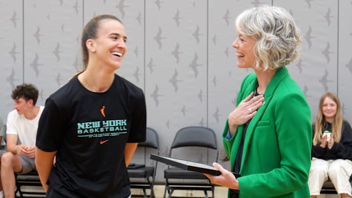 Eugene Mayor Kaarin Knudson, rght, presents Sabrina Ionescu with a plaque declaring May 12 “Sabrina Ionescu Day” in Eugene.