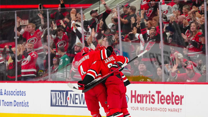 Oct 15, 2024; Raleigh, North Carolina, USA;  Carolina Hurricanes center Seth Jarvis (24) is congratulated by  defenseman Shayne Gostisbehere (4) and center Jack Drury (18) after his goal against the New Jersey Devils during the second period at PNC Arena. Mandatory Credit: James Guillory-Imagn Images