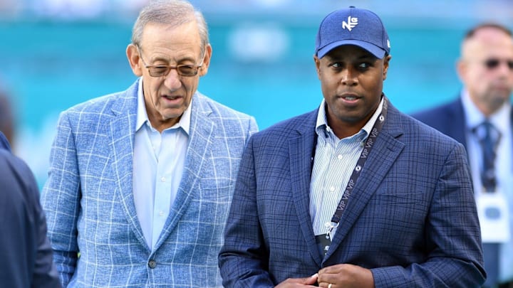 Dolphins owner Stephen Ross (left) talks with general manager Chris Grier before a game in