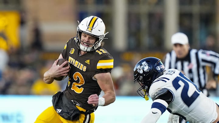 Oct 26, 2024; Laramie, Wyoming, USA; Wyoming Cowboys quarterback Kaden Anderson (12) runs against the Utah State Aggies during the first quarter at Jonah Field at War Memorial Stadium. Mandatory Credit: Troy Babbitt-Imagn Images