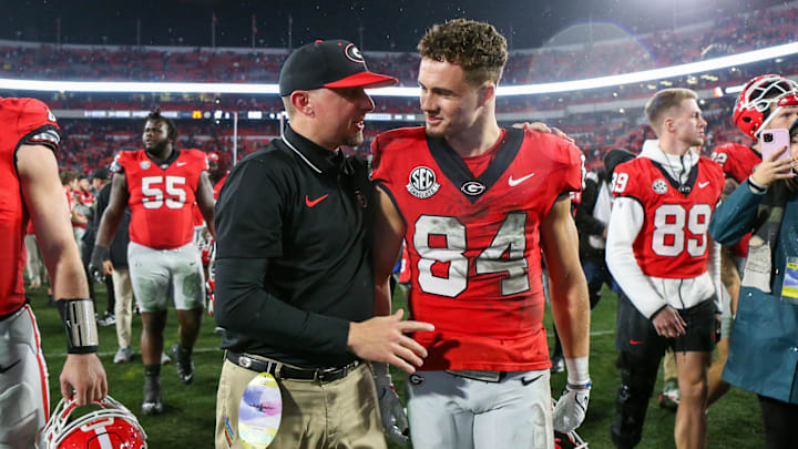 Nov 11, 2023; Athens, Georgia, USA; Georgia Bulldogs tight end coach Todd Hartley talks to wide receiver Ladd McConkey (84) after a victory against the Mississippi Rebels at Sanford Stadium. Mandatory Credit: Brett Davis-Imagn Images