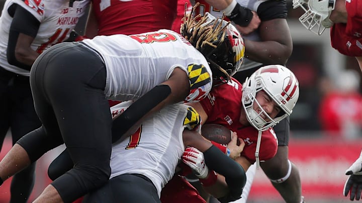 Wisconsin quarterback Graham Mertz (5) is sacked by Maryland linebacker Jaishawn Barham (1) and linebacker VanDarius Cowan (8) at Camp Randall Stadium in Madison, Wis. Wisconsin won the game, 23-10.