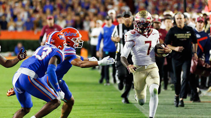 Nov 29, 2025; Gainesville, Florida, USA; Florida State Seminoles wide receiver Lawayne McCoy (7) runs against Florida Gators defensive back Alfonzo Allen Jr. (43) during the second half at Ben Hill Griffin Stadium. Mandatory Credit: Matt Pendleton-Imagn Images