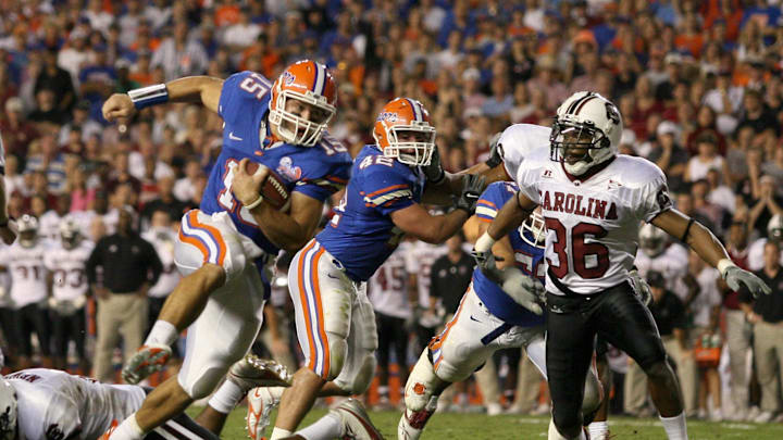 Nov 11, 2006; Gainesville, FL, USA; Florida Gators quarterback (15) Tim Tebow runs for a touchdown to tie the score during the fourth quarter against the South Carolina Gamecocks at Ben Hill Griffin Stadium in Gainesville, FL. The extra point put the Gators up by one and they defeated the Gamecocks 17-16. Mandatory Credit: Jason Parkhurst-Imagn Images Copyright © 2006 Jason Parkhurst