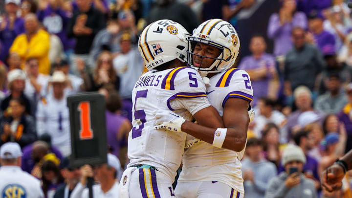 LSU Tigers quarterback Jayden Daniels hugs wide receiver Kyren Lacy.