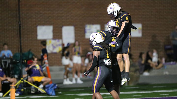 Caden Arnold (6) and Edward Coleman (1) celebrate with Michael Smith after he scored on a 73-yard touchdown during Friday night's game against Eagle's Landing.