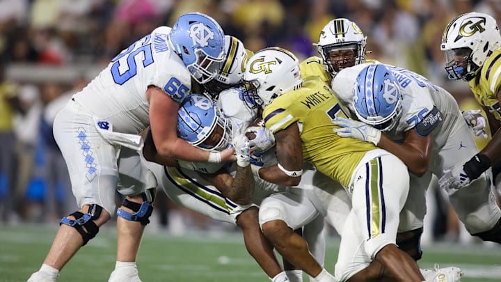 Oct 28, 2023; Atlanta, Georgia, USA; North Carolina Tar Heels running back Omarion Hampton (28) is tackled by Georgia Tech Yellow Jackets defensive lineman Josh Robinson (27) and linebacker Andre White (3) in the second half at Bobby Dodd Stadium at Hyundai Field. Mandatory Credit: Brett Davis-Imagn Images