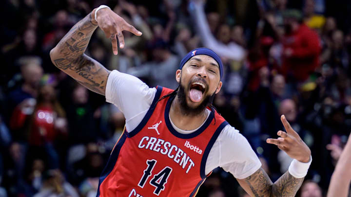 Feb 5, 2024; New Orleans, Louisiana, USA; New Orleans Pelicans forward Brandon Ingram (14) celebrates a three point basket against Toronto Raptors center Jakob Poeltl (19) during the second half at Smoothie King Center. Mandatory Credit: Matthew Hinton-Imagn Images