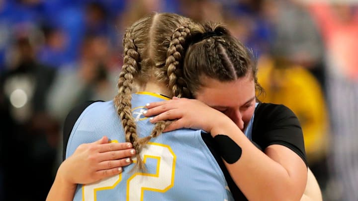 Saint Mary Catholic High School's Piper Neubauer (22) and Bella Woodbridge (23) embrace after a loss to Albany/Monticello High School during their WIAA Division 4 semifinal girls basketball game Thursday, March 12, 2026, at the Resch Center in Ashwaubenon, Wisconsin.