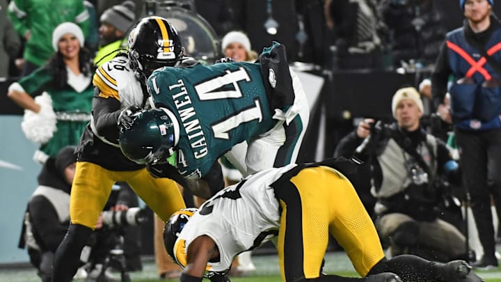 Dec 15, 2024; Philadelphia, Pennsylvania, USA; Philadelphia Eagles running back Kenneth Gainwell (14) is upended by Pittsburgh Steelers safety Damontae Kazee (23) and cornerback Donte Jackson (26) during the second quarter at Lincoln Financial Field. Mandatory Credit: Eric Hartline-Imagn Images