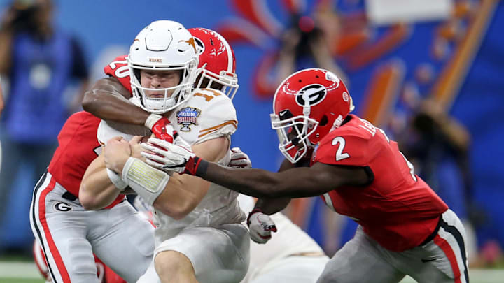 Jan 1, 2019; New Orleans, LA, USA; Texas Longhorns quarterback Sam Ehlinger (11) is tackled by Georgia Bulldogs defensive backs J.R. Reed (20) and Richard LeCounte (2) in the second half of the 2019 Sugar Bowl at the Mercedes-Benz Superdome. Mandatory Credit: Chuck Cook-Imagn Images Jan 1, 2019; New Orleans, LA, USA; Texas Longhorns quarterback Sam Ehlinger (11) is tackled by Georgia Bulldogs defensive backs J.R. Reed (20) and Richard LeCounte (2) in the second half of the 2019 Sugar Bowl at the Mercedes-Benz Superdome. Mandatory Credit: Chuck Cook-Imagn Images