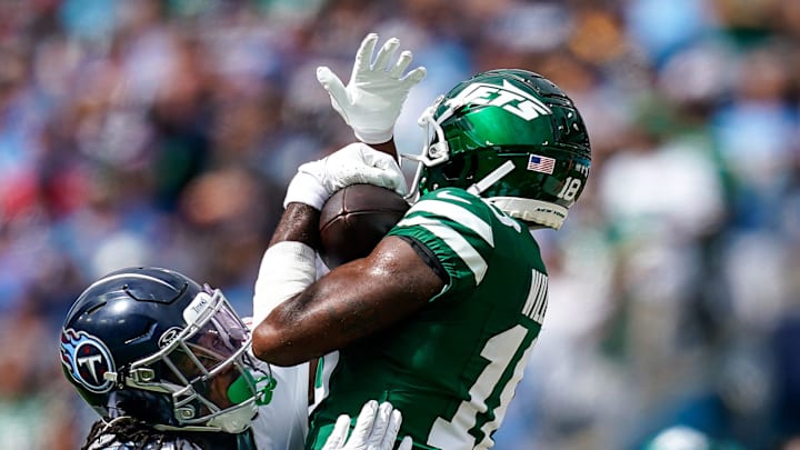 New York Jets wide receiver Mike Williams (18) receives a pass over Tennessee Titans cornerback Chidobe Awuzie (13) during the fourth quarter at Nissan Stadium in Nashville, Tenn., Sunday, Sept. 15, 2024.