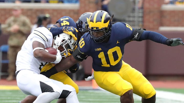 Michigan defenders Josh Metellus (14) and line backer Devin Bush (10) tackle Western Michigan running back LeVante Bellamy Michigan defenders Josh Metellus (14) and line backer Devin Bush (10) tackle Western Michigan running back LeVante Bellamy