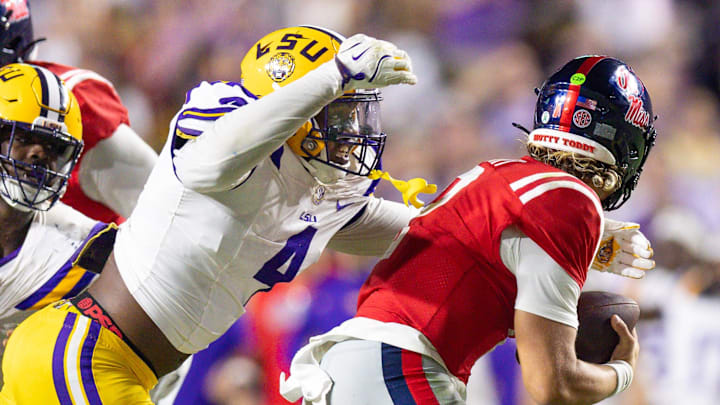 Oct 12, 2024; Baton Rouge, Louisiana, USA; LSU Tigers defensive end Bradyn Swinson (4) sacks Mississippi Rebels quarterback Jaxson Dart (2) during the second half at Tiger Stadium. Mandatory Credit: Stephen Lew-Imagn Images Oct 12, 2024; Baton Rouge, Louisiana, USA; LSU Tigers defensive end Bradyn Swinson (4) sacks Mississippi Rebels quarterback Jaxson Dart (2) during the second half at Tiger Stadium. Mandatory Credit: Stephen Lew-Imagn Images